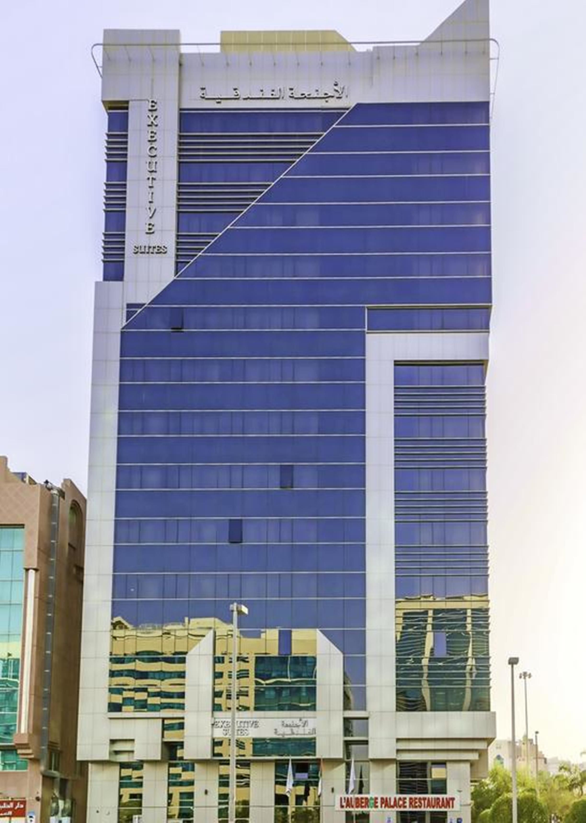 Edifici modern amb façana de vidre i indicadors que diuen 'EXECUTIVE SUITES'.