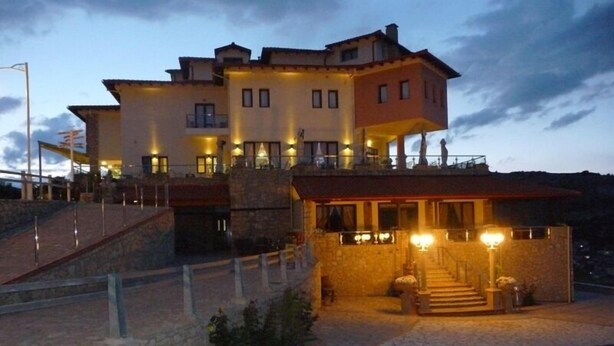 A multi-story building with a stone facade, a balcony, and a staircase leading to the entrance. - Afkos Grammos Luxury Boutique Hotel (Nestorio)