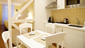 Una cocina compacta con muebles blancos, un microondas integrado y un lavabo.