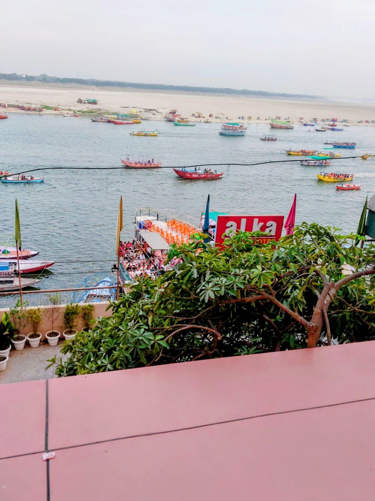 A river with numerous boats and a view of a building with a sign that reads 'AUKA'.