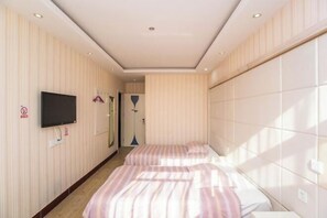 A hotel room with two beds, a TV mounted on the wall, and a large window providing natural light. - Aike 100 Theme Hotel (Qingdao Chongqing North Road Liuting Subway Station) (Qingdao)