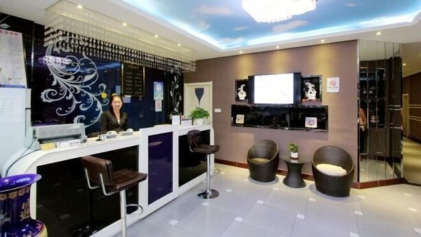 Un área de recepción moderna con barra, asientos y un techo decorativo.