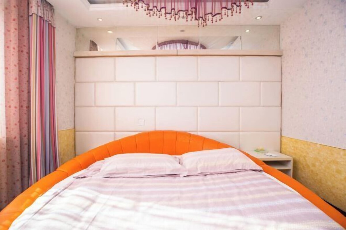 A bedroom with a bed, a nightstand, and a headboard.