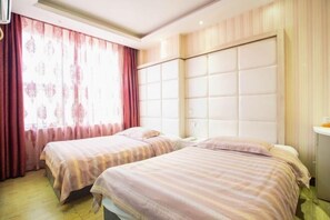 A hotel room with two beds, a large window with curtains, and a padded headboard. - Aike 100 Theme Hotel (Qingdao Chongqing North Road Liuting Subway Station) (Qingdao)