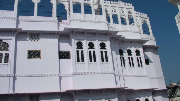 A white building with multiple windows and decorative arches. - Bhanwar Vilas Guest House (Udaipur)