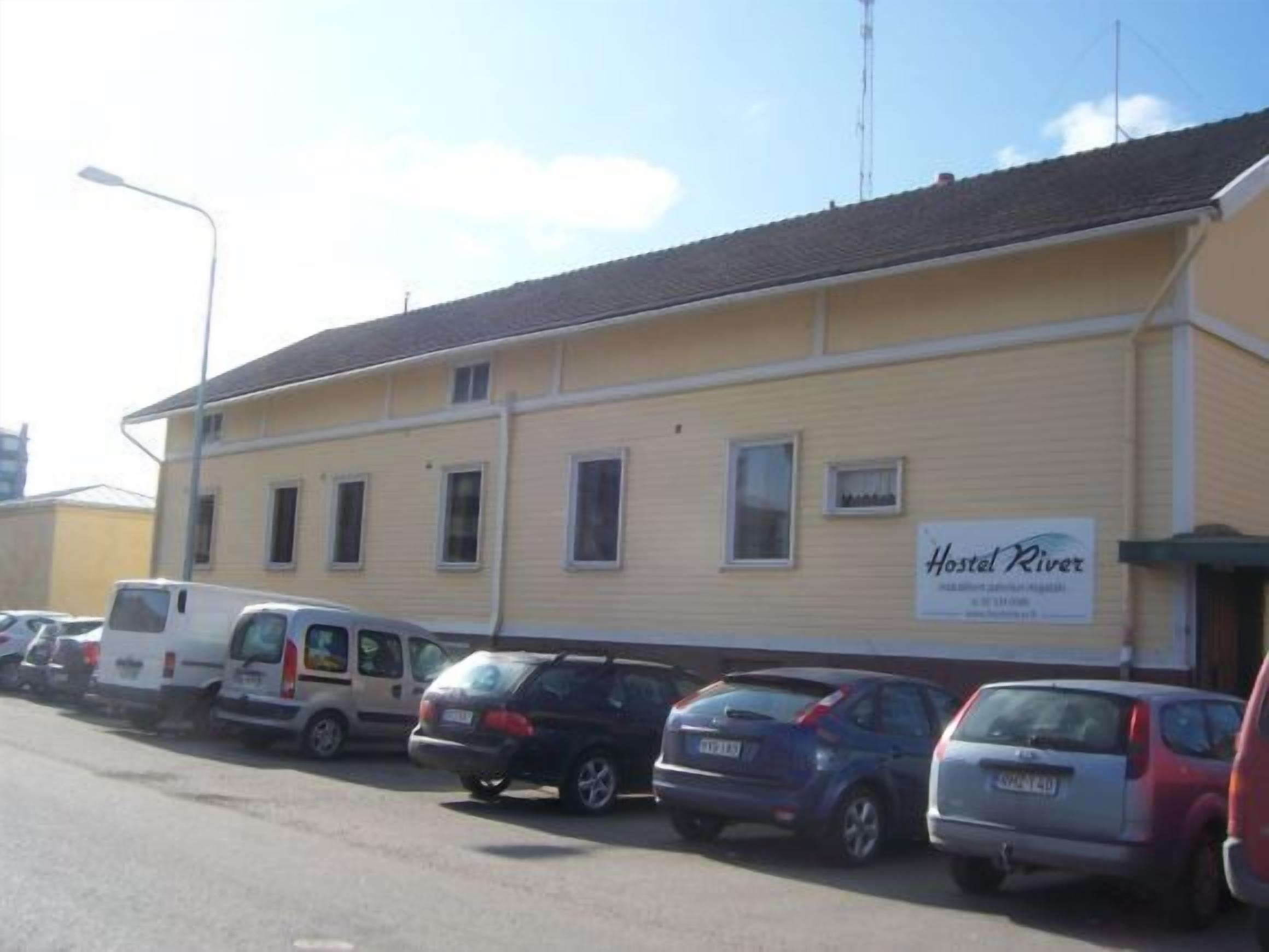 A yellow building with a sign reading "Hotel River."