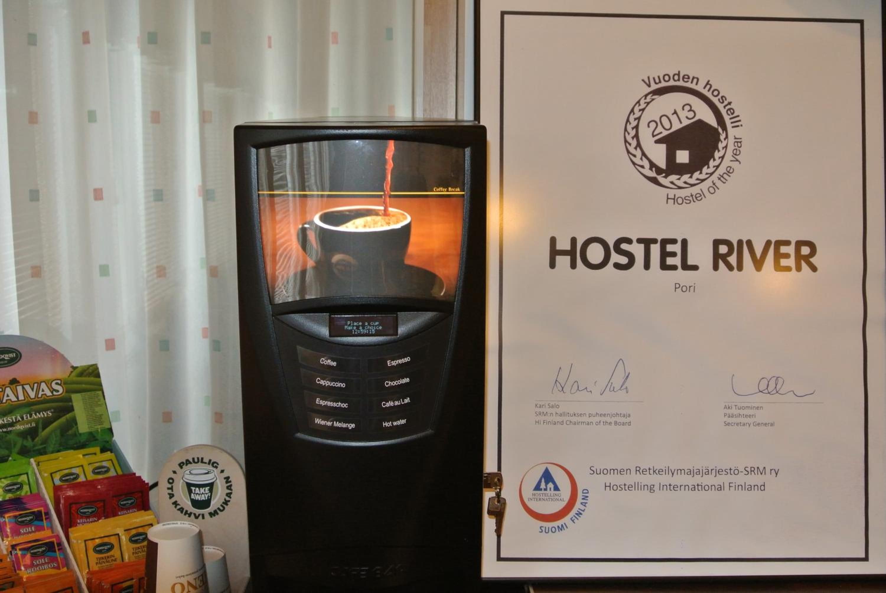 A coffee machine with a digital display, a framed certificate, and a variety of coffee pods.