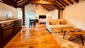 A cozy, open-plan living space with a kitchen, dining area, and a bedroom. - Domaine du Moulin de Champie – Plaine de Versailles (Davron)