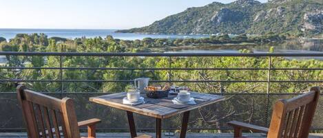 A table with a view of a lake and mountains.
