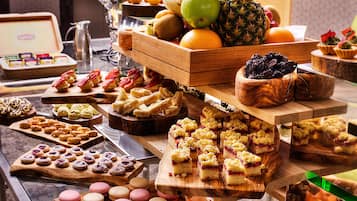 Un bufé con diversos postres y frutas.