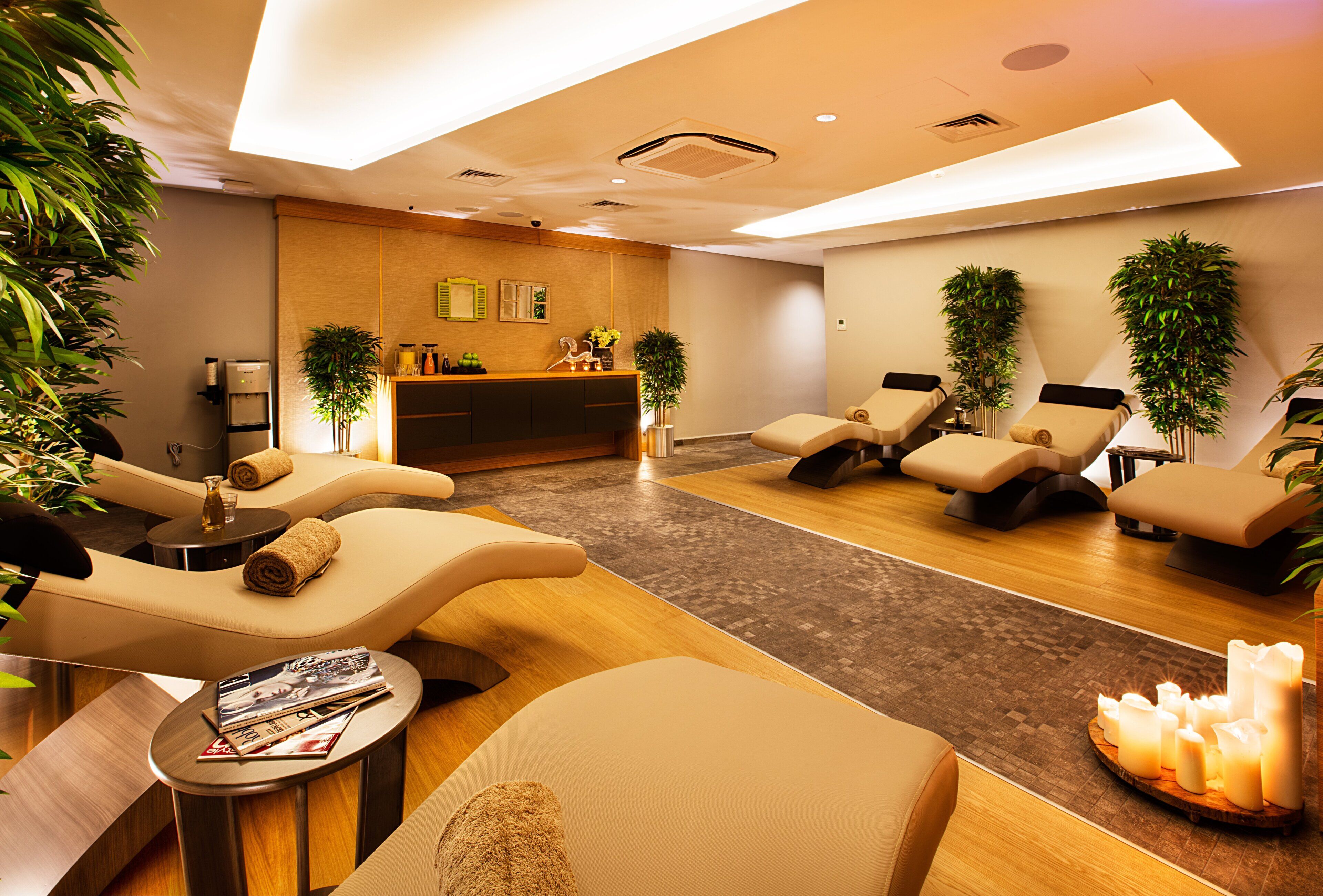 A spa room with massage chairs, a reception desk, and plants.