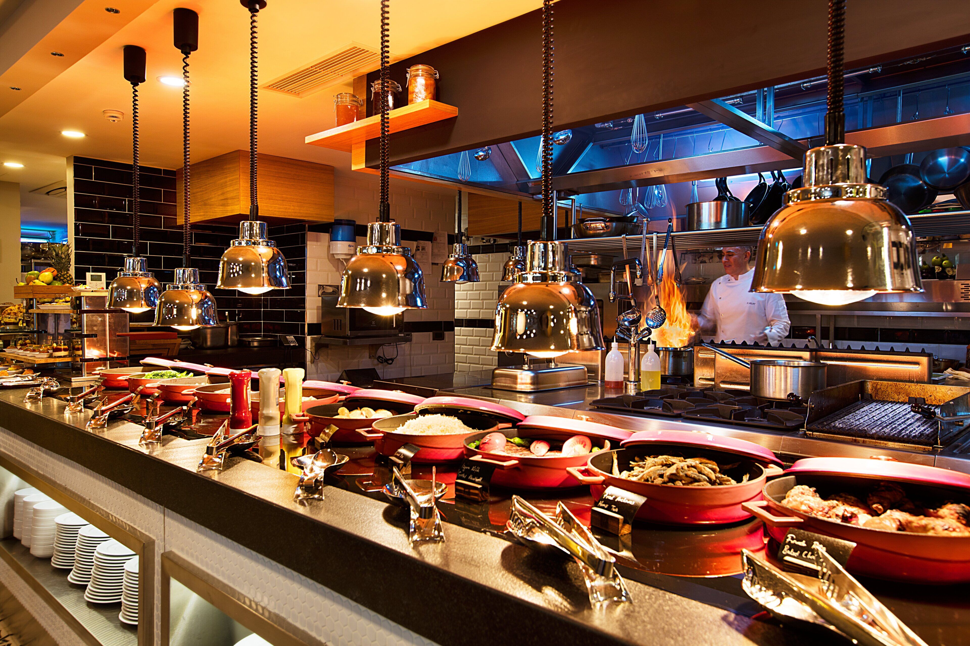 Una mesa de buffet con diversos alimentos y utensilios.