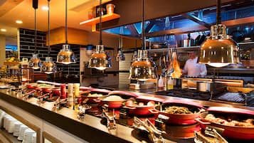 Una mesa de buffet con diversos alimentos y utensilios.