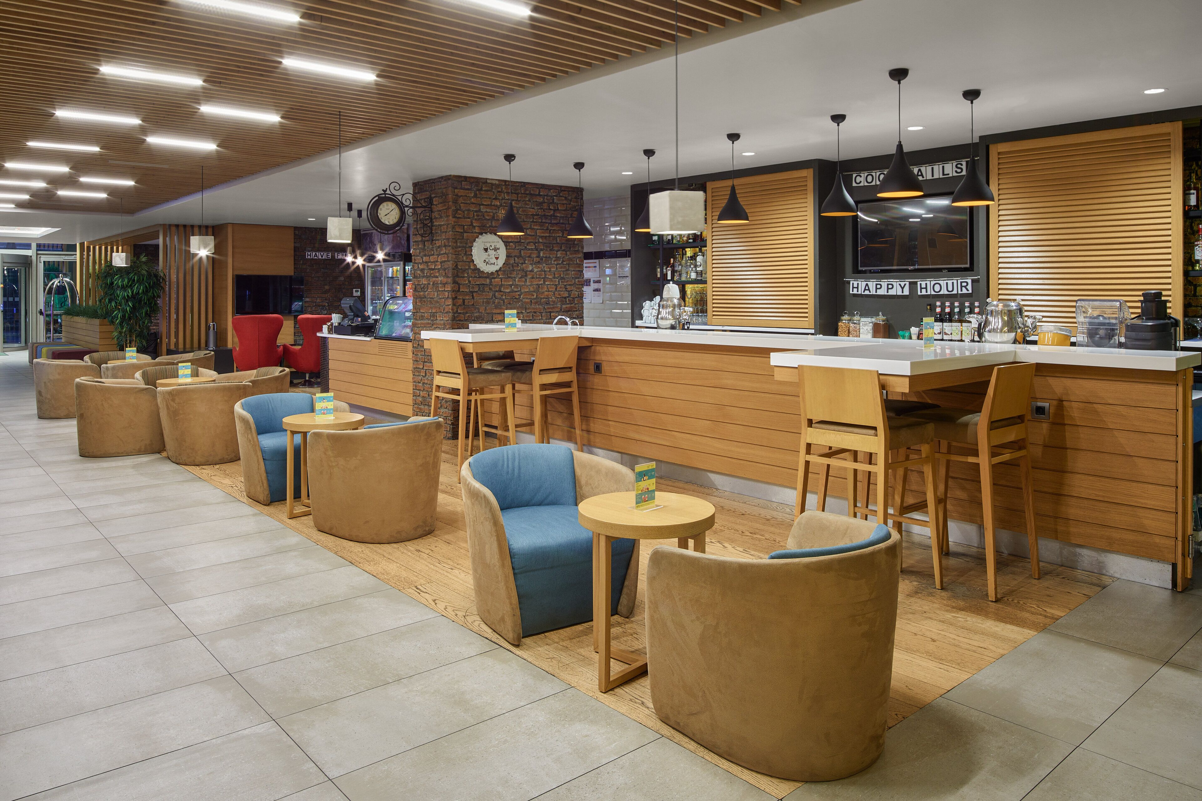 A modern cafe with wooden furniture, a bar area, and a clock on the wall.
