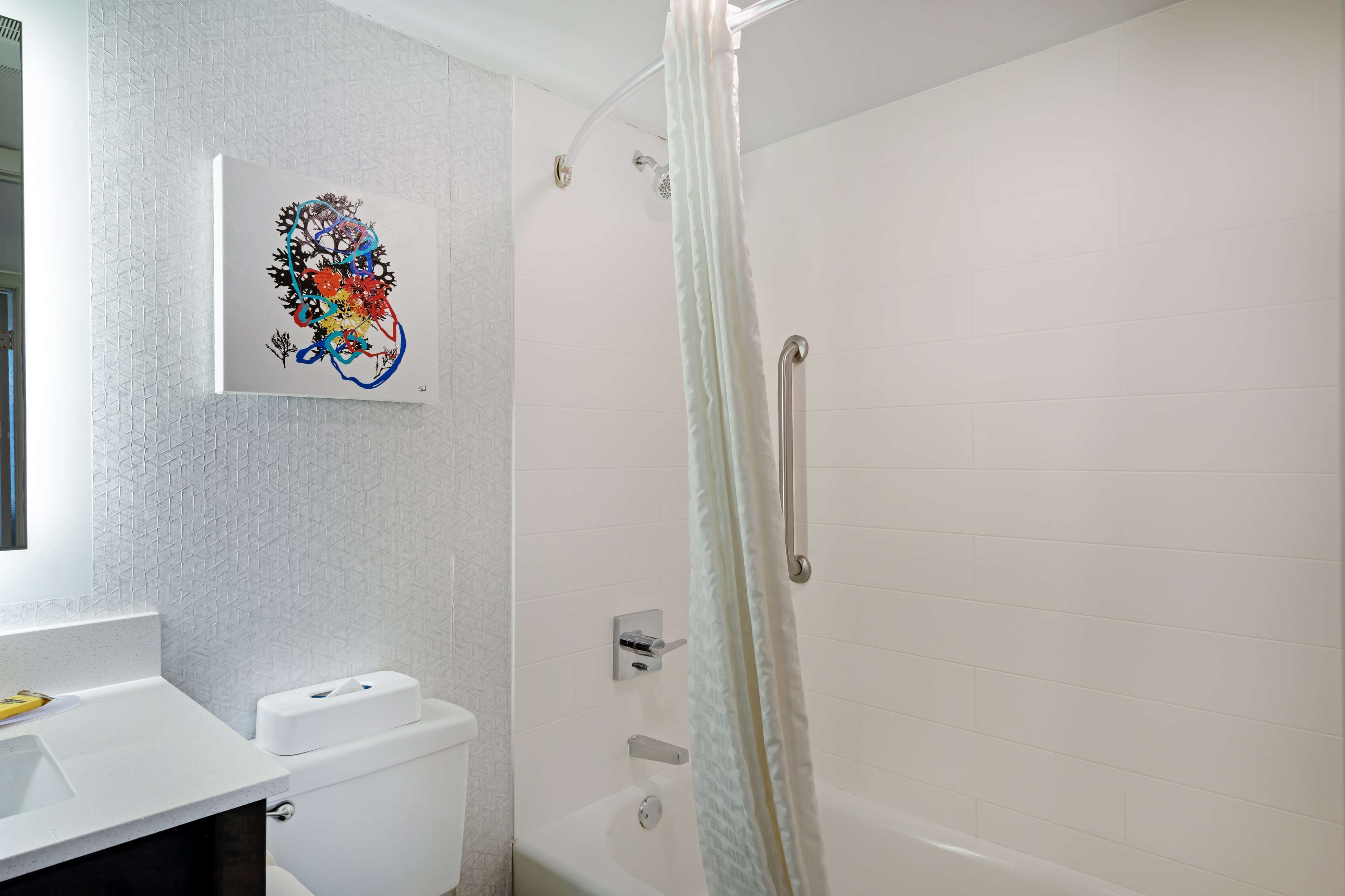 A modern bathroom with a shower, toilet, and sink.