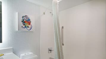 A modern bathroom with a shower, toilet, and sink.