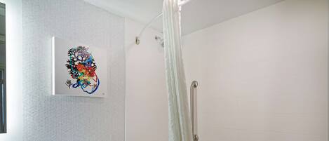 A modern bathroom with a shower, toilet, and sink.