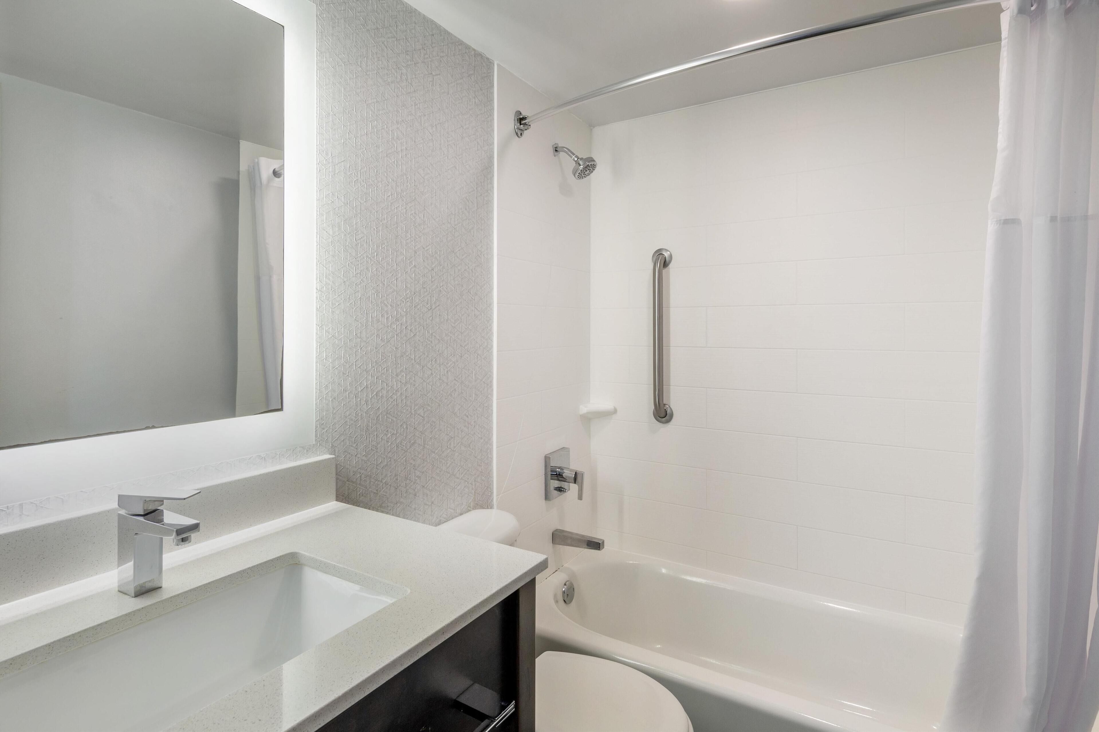 Une salle de bain moderne avec un lavabo blanc, des toilettes et une baignoire.