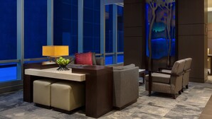 A modern hotel room with a large window, a desk with a lamp, a sofa, and a chair. - Hyatt Place Chicago/Downtown - The Loop (Chicago)