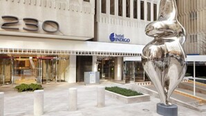 A hotel entrance with a large number '230' above the doors, a modern sculpture in the foreground, and a 'hotel INDIGO' sign above the entrance. - Hotel Indigo Atlanta Downtown by IHG (Atlanta)