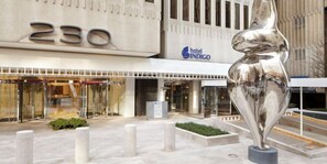 A hotel entrance with a large number '230' above the doors, a modern sculpture in the foreground, and a 'hotel INDIGO' sign above the entrance. - Hotel Indigo Atlanta Downtown by IHG (Atlanta)