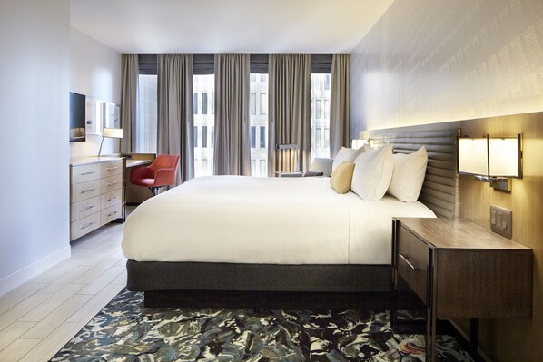 A modern hotel room with a large bed, a desk, a chair, and a view of the city through large windows. - Hotel Indigo Atlanta Downtown by IHG (Atlanta)