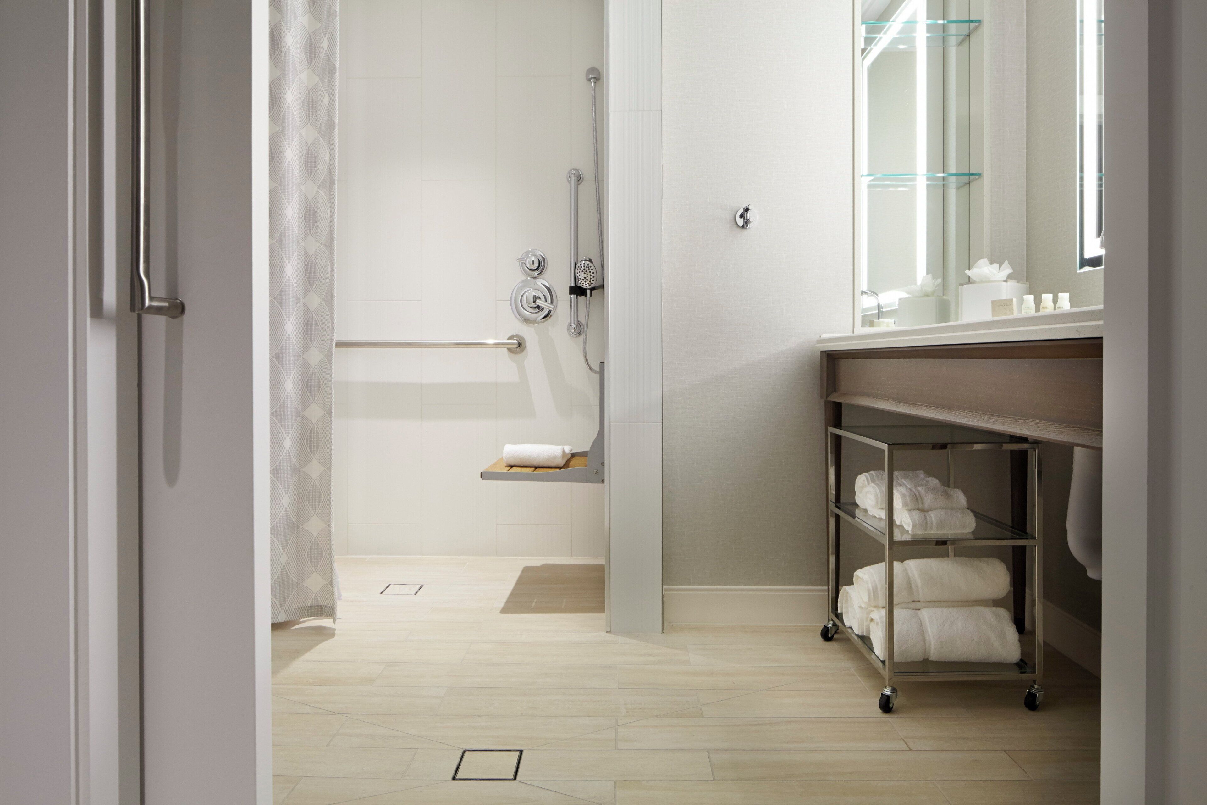A modern bathroom with a shower, a toilet, a sink, and a vanity with a mirror.