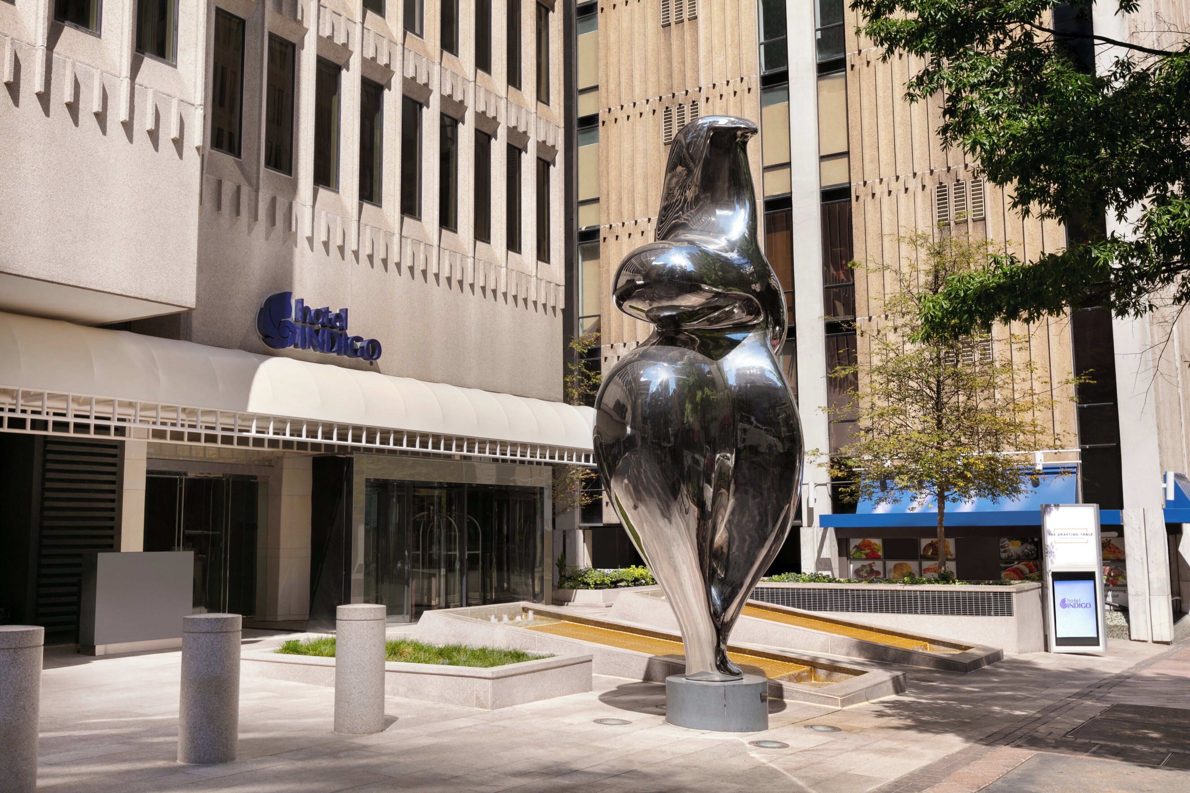 A modern building with a prominent sculpture in front.