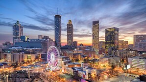 A cityscape with tall buildings, a prominent Ferris wheel, and a clear sky at dusk. - Hotel Indigo Atlanta Downtown by IHG (Atlanta)
