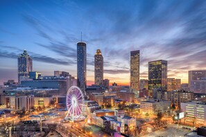 A cityscape with tall buildings, a prominent Ferris wheel, and a clear sky at dusk. - Hotel Indigo Atlanta Downtown by IHG (Atlanta)