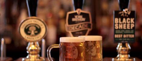 Two beer taps with labels "Black Sheep" and "Decade" and two glasses of beer in front of them.