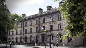 A historic building with the name "White Hart Hotel" prominently displayed. It features a classic architectural style with arched windows and a stone facade.