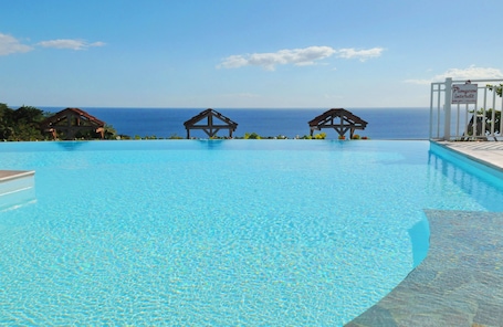 Outdoor pool, pool umbrellas, pool loungers. Le Village Pomme Cannelle