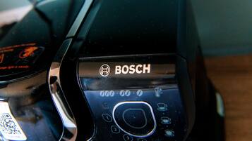 A close-up of a Bosch appliance control panel with a QR code and a circular dial.