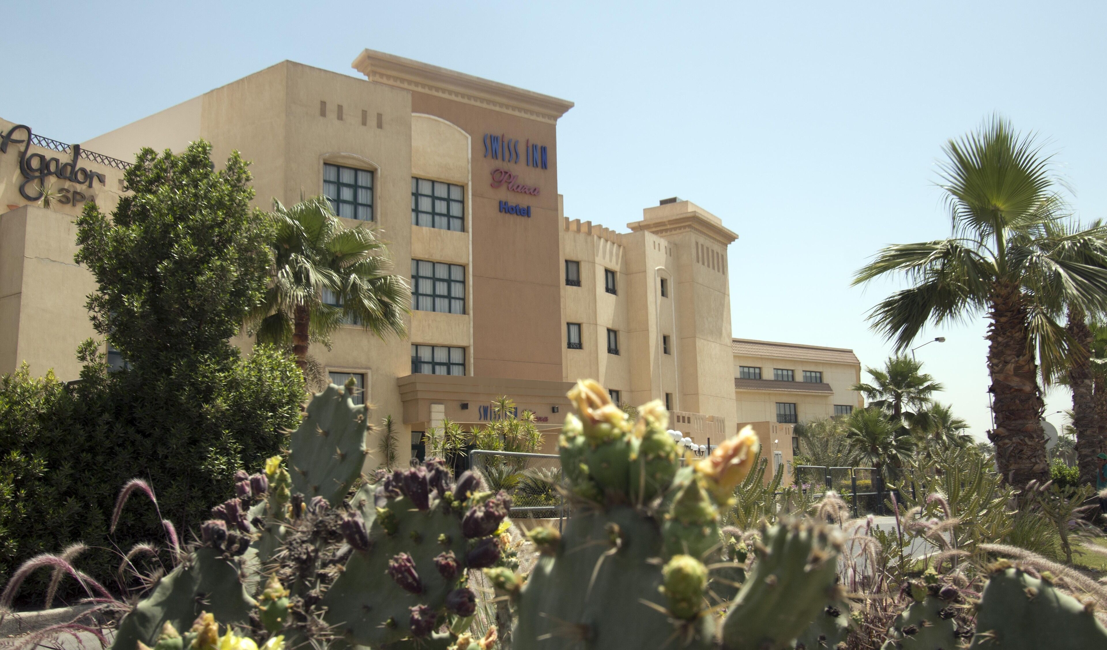 Un hotel con un cartel que dice "Swiss Inn Plaza Hotel".