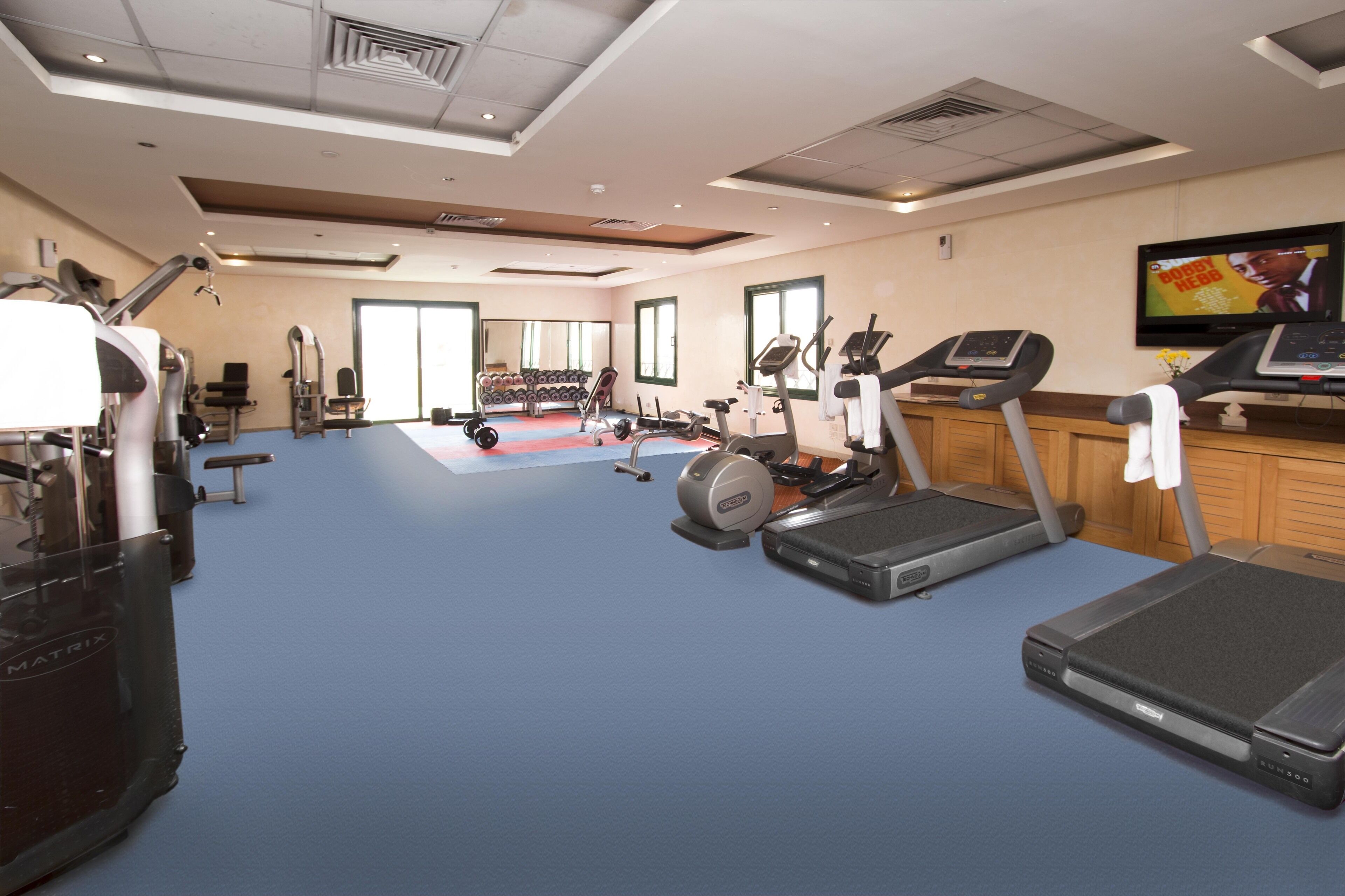 Un gimnasio con cintas de correr, bicicletas estáticas y máquinas de pesas.