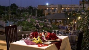 A table set for dining with a view of a cityscape at dusk.