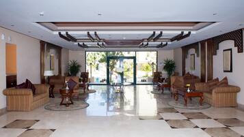 Relax in the spacious lobby area with high ceilings, a checkered floor, and comfortable seating.