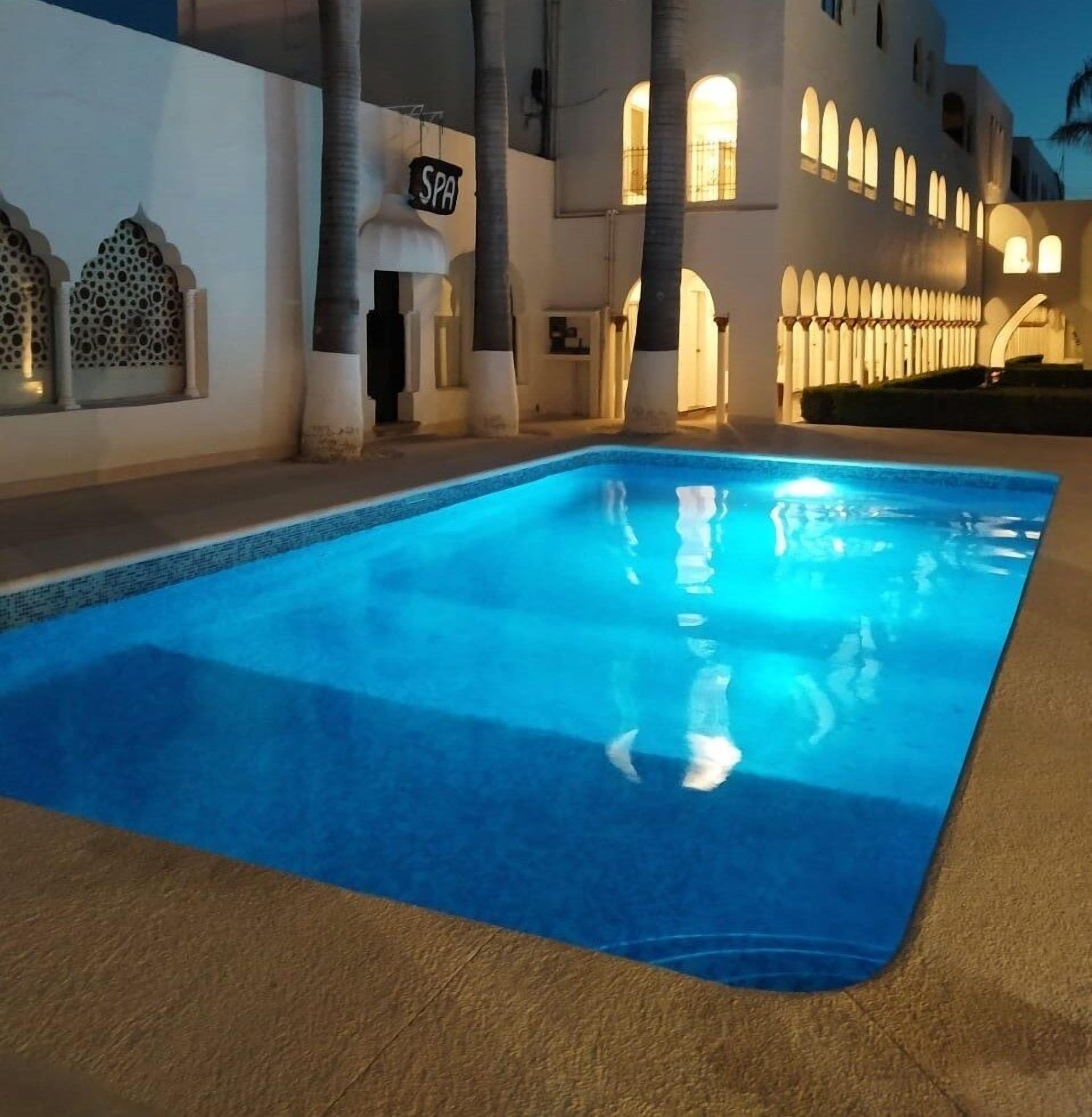 Une piscine avec un panneau indiquant « SPA » en arrière-plan.