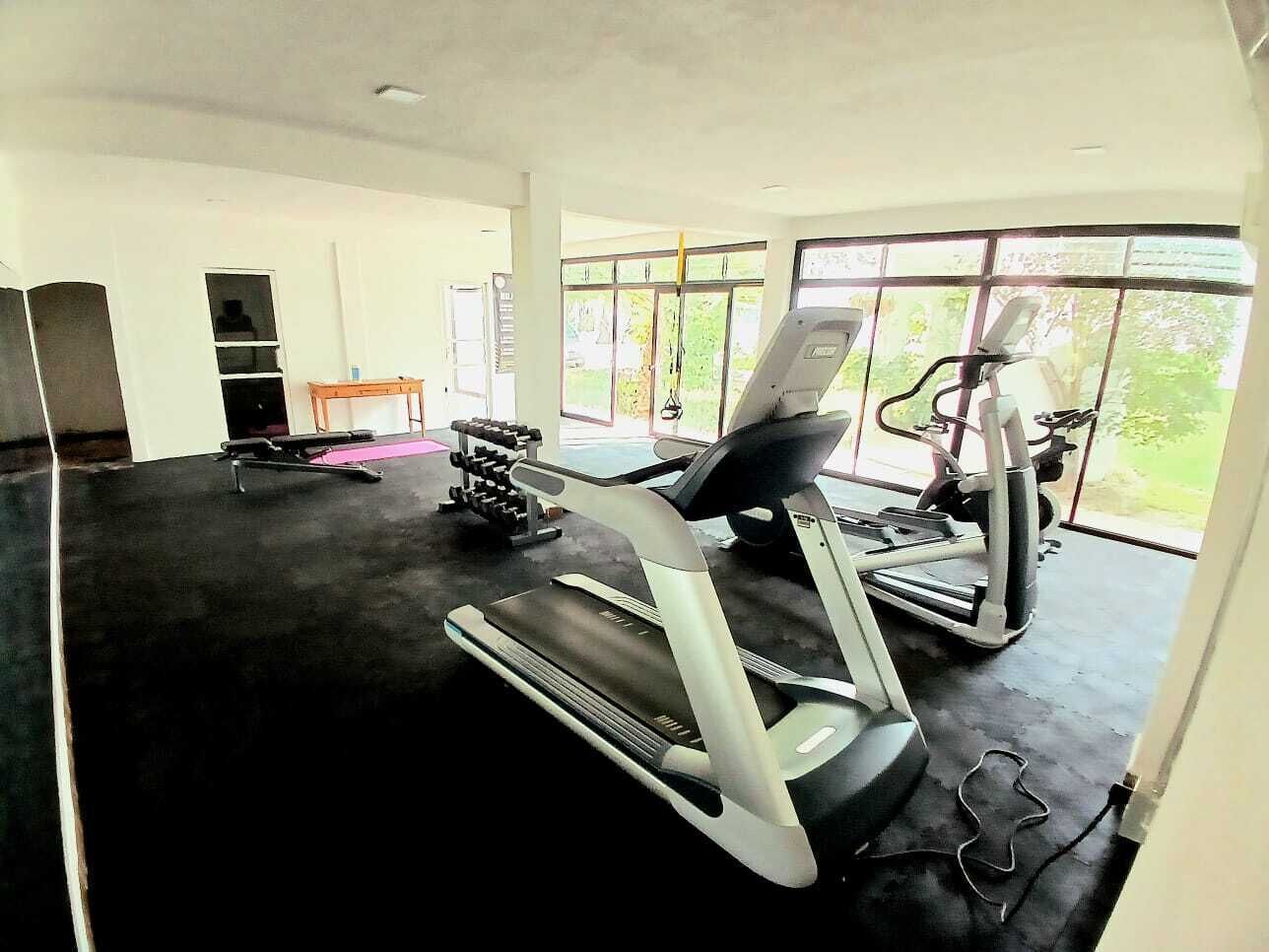 A gym with treadmills, a stationary bike, and weight machines.