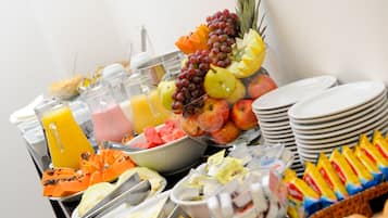 A buffet with various fruits, juices, and breakfast items.