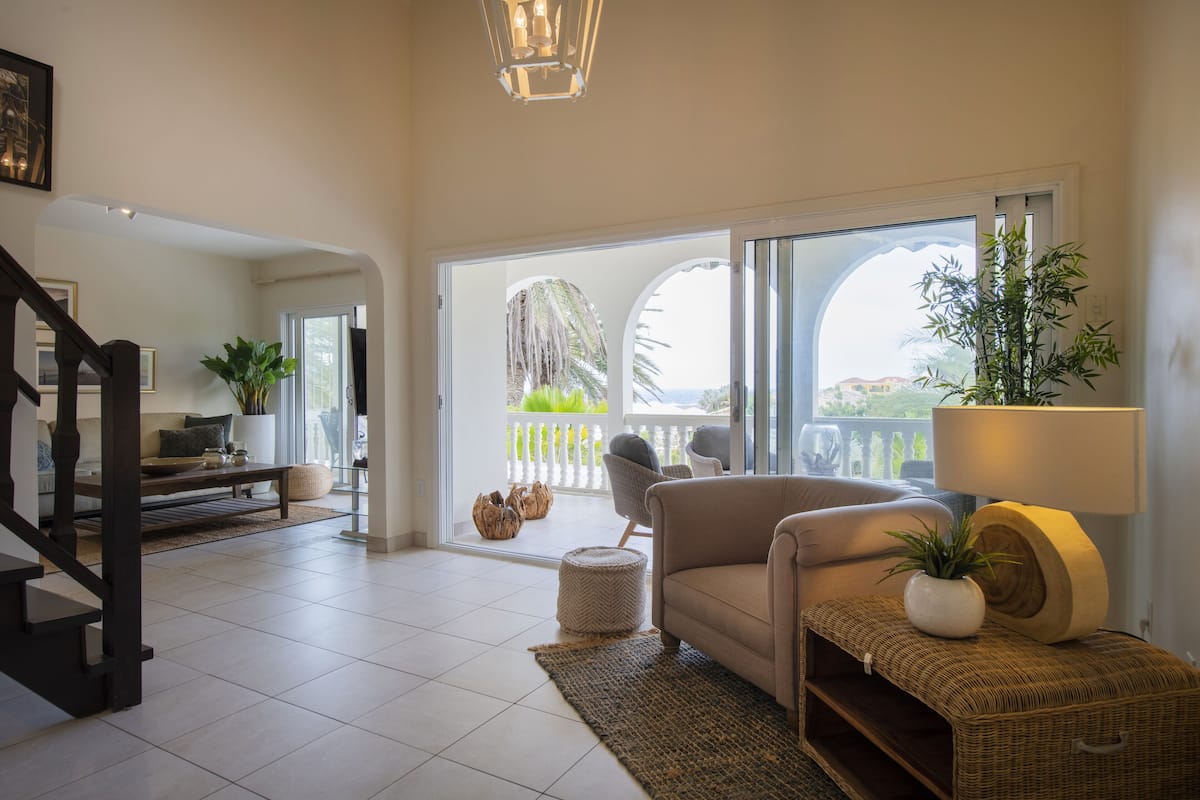 Un espacio habitable amplio con sofá, sillones, una mesa de centro y un gran ventanal con vistas al exterior.