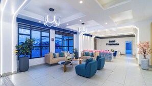 A modern hotel lobby with a reception desk, seating area, and large windows. - Presidente Beach (Salinas)