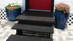 A red door with a black frame, flanked by two large blue flower pots on either side. - The Loft at Menorcan Square (St. Augustine)