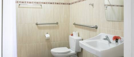 A bathroom with a toilet, sink, and shower.