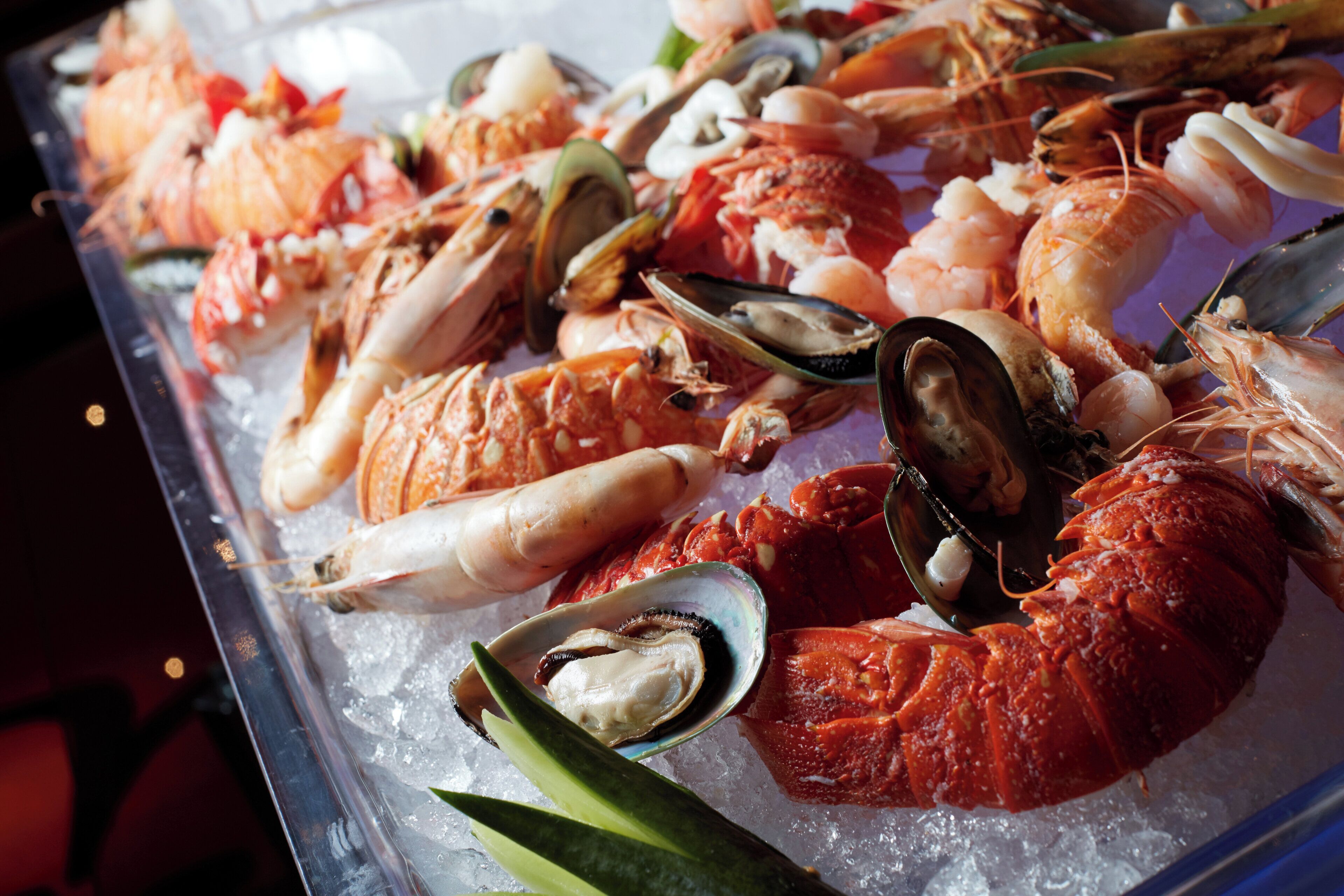 A seafood display with various shellfish on ice.