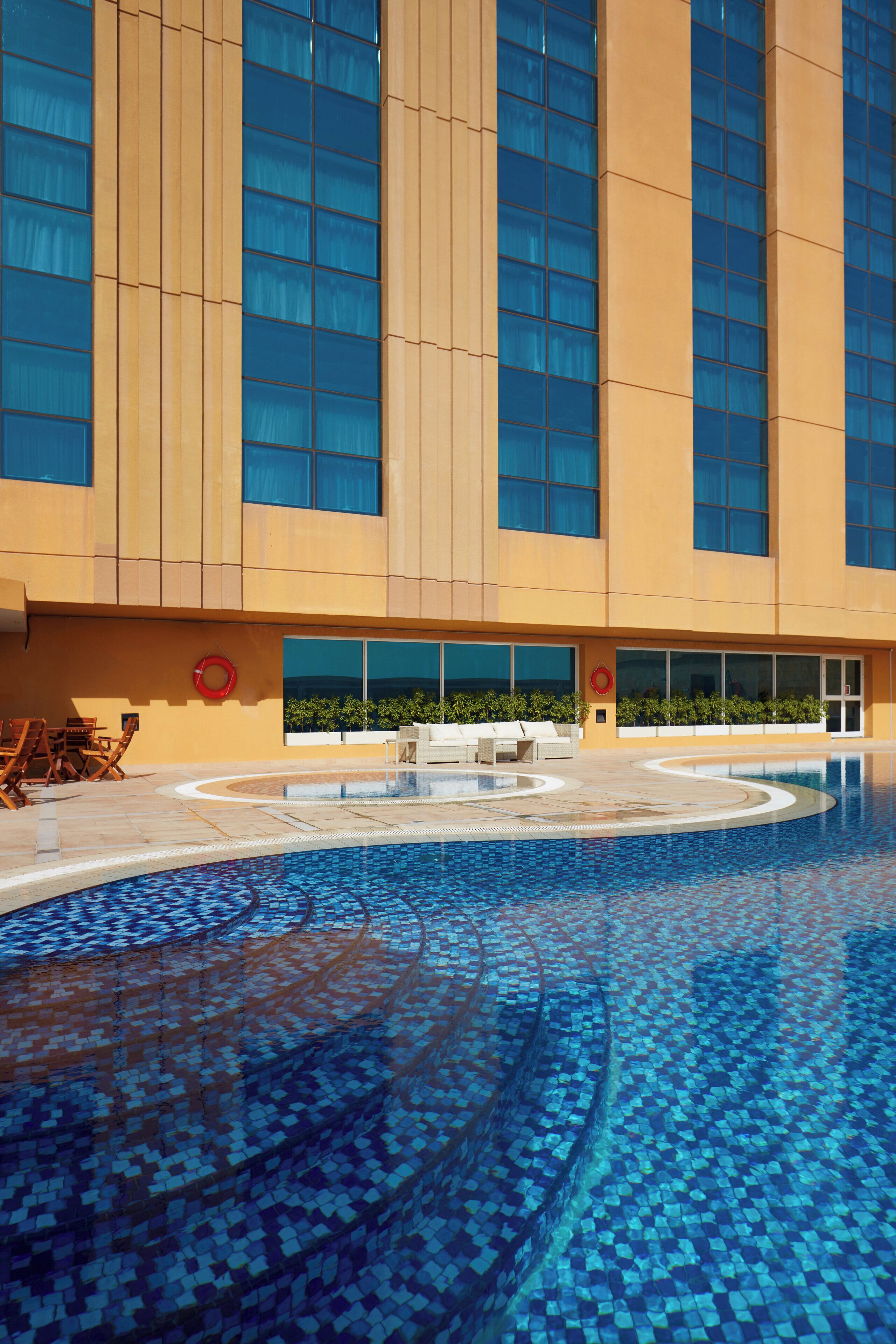 Una piscina al aire libre, tumbonas