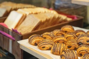 A display of pastries and bread in a bakery setting. - Millennium Hotel and Convention Centre Kuwait (Salmiya)