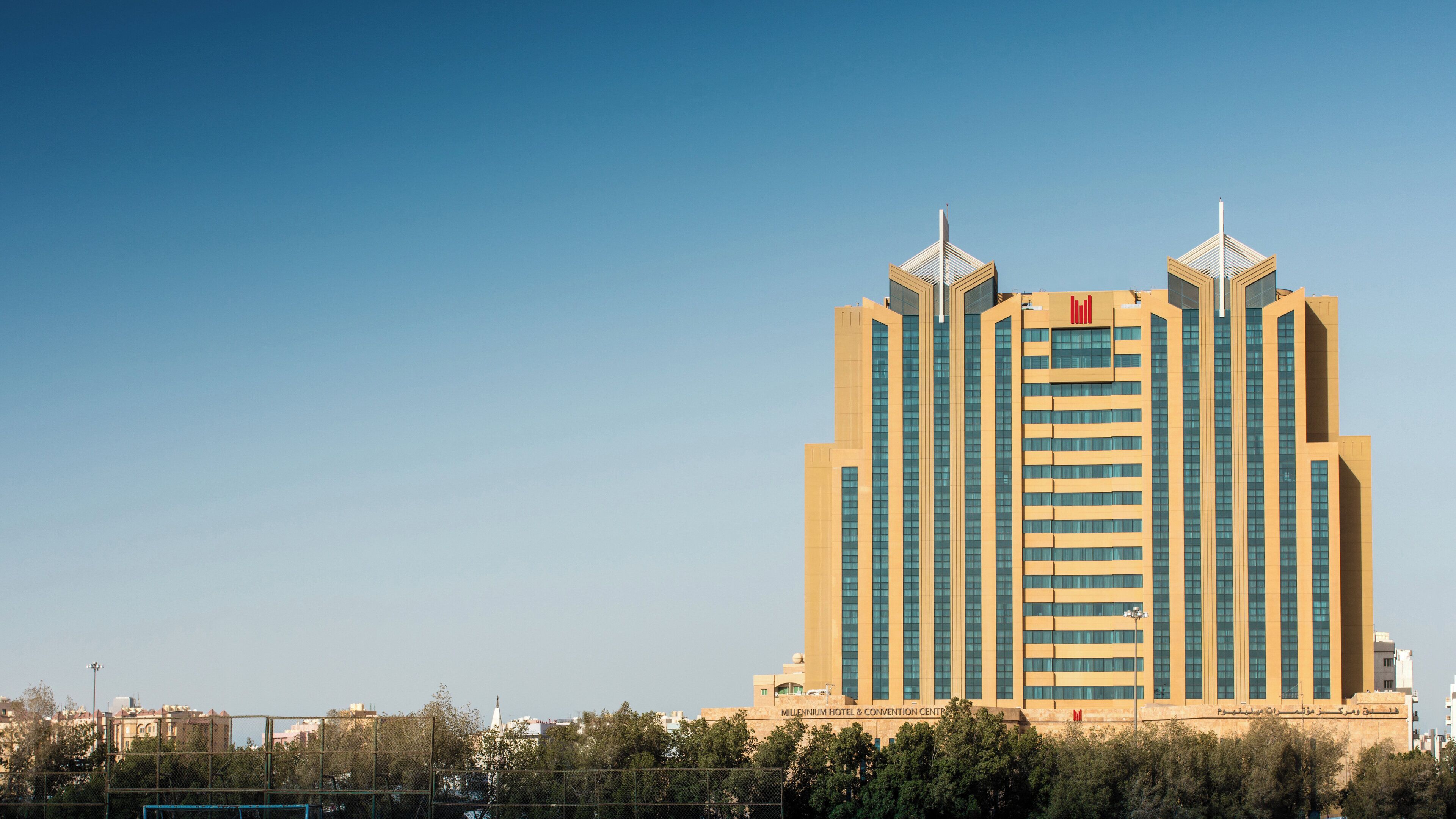 A tall, modern hotel with a symmetrical facade, featuring a central entrance and two symmetrical towers with spires.
