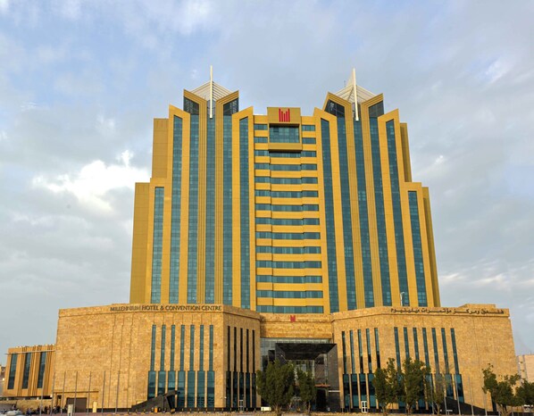 A large, modern hotel with a prominent central tower and symmetrical design. - Millennium Hotel and Convention Centre Kuwait (Salmiya)